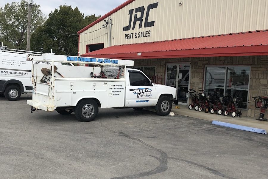 Wald Plumbing's white service truck, with the company name and phone number on the side